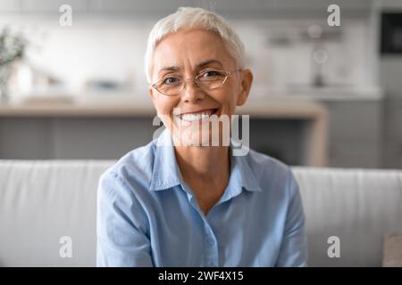 Portrait en gros plan de dame âgée heureuse avec des lunettes élégantes à l'intérieur Banque D'Images