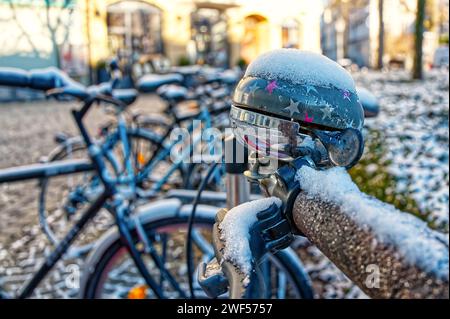 Vue détaillée d'une cloche de vélo décorée d'étoiles de différentes couleurs, couverte par la neige Banque D'Images