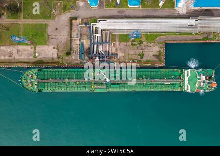 Vue aérienne de haut en bas navire pétrolier chargement dans la raffinerie de station de terminal de gaz et de pétrole, Global trading import export transport logistique mer Banque D'Images