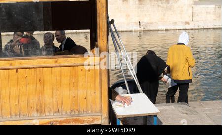 Touristes à l'alimentation des carpes, Balıklıgöl (ou piscine d'Abraham, Halil-Ür Rahman Lake), est une piscine dans le sud-ouest du centre-ville de Şanlıurfa, Turquie Banque D'Images