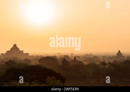 Paysage pittoresque et silhouette de nombreux temples anciens et pagodes à la plaine de Bagan au Myanmar (Birmanie) au lever du soleil. Banque D'Images