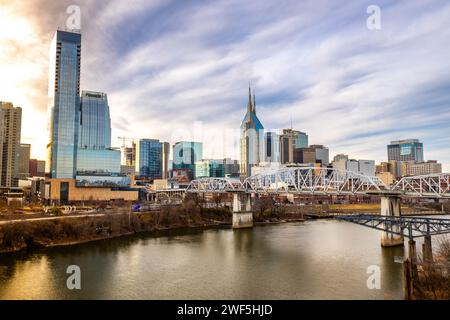 Nashville, TN, États-Unis - 12-24-2023 : vue panoramique sur les gratte-ciel du centre-ville de Nashville et la rivière Cumberland au coucher du soleil Banque D'Images