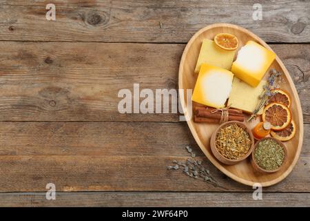 Composition Flat Lay avec savon naturel fait à la main et ingrédients sur table en bois, espace pour le texte Banque D'Images