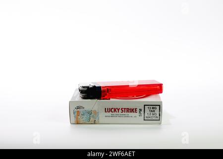 Paquets de cigarettes British American Tobacco Lucky Strike avec briquet rouge isolé sur fond blanc Banque D'Images