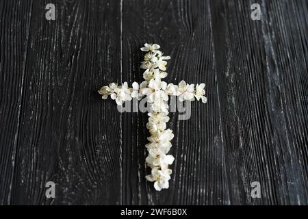 Croix avec des fleurs sur un fond de bois avec l'inscription Christ is ressuscité Banque D'Images