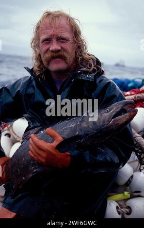 Le membre d'équipage Mel White du bateau de pêche commercial Yankee Maid tient un saumon royal à Hidden Falls, dans le sud-est de l'Alaska Banque D'Images