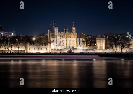 Une vue générale de la Tour de Londres la nuit avec des reflets lumineux sur la Tamise. Photographie nocturne à exposition longue. Banque D'Images