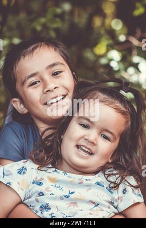 Image en gros plan de deux jeunes sœurs maories posant pour que leur photographie soit prise à l'extérieur dans un cadre naturel. Banque D'Images