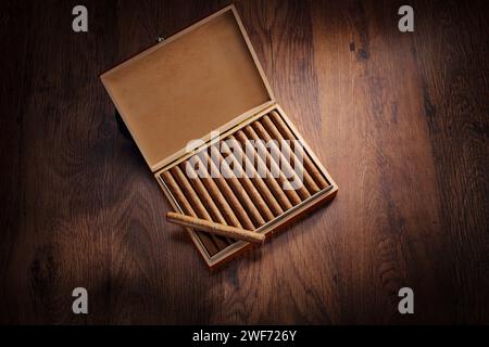 Vue de dessus des cigares dans une boîte placée sur un plancher en bois Banque D'Images