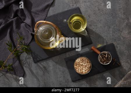 ensemble de tasses et théière avec tournesol, graines de citrouille sur fond sombre, vue de dessus, pose à plat Banque D'Images