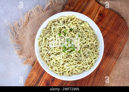 Pose à plat de nouilles ramen épinards et chou frisé sur une surface rustique avec du bois et de la toile de jute Banque D'Images