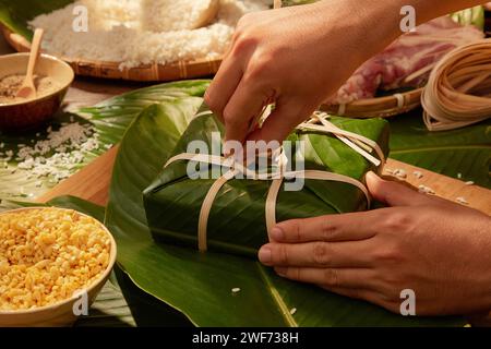 Mains de la personne faisant des gâteaux de riz collants traditionnels. Cadeau traditionnel pour le nouvel an lunaire. Vietnamien traditionnel Banque D'Images