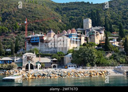 Vue aérienne des maisons pittoresques au bord de l'eau nichées sur une colline, avec une colline pittoresque au loin Banque D'Images