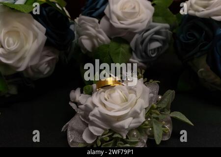 Un gros plan d'anneaux de mariage couchés délicatement au sommet d'un beau bouquet de mariée pendant le mariage de Gaddy à Hurricane, WV Banque D'Images