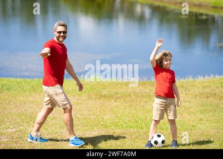 Père et fils font partie d'une famille sportive qui aime jouer au football ensemble. Ils passent les week-ends sur le terrain en pratiquant leurs compétences et ayant Banque D'Images