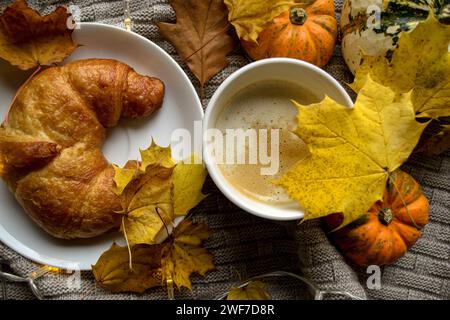 Café chaud et un croissant français dans un beau bol pour le petit déjeuner au lit Banque D'Images