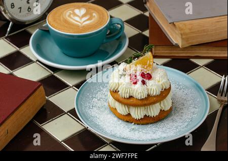 café et dessert sont sur la table, montres et livres sont à proximité Banque D'Images