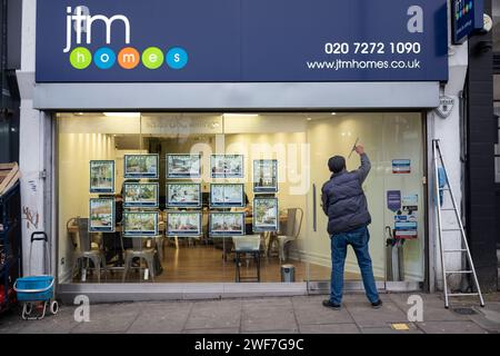 JTM Homes : agents immobiliers a nettoyé sa vitre début janvier 2024, Aldgate, Nord de Londres, Royaume-Uni Banque D'Images