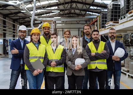 Équipe complète d'employés d'entrepôt debout dans l'entrepôt. Équipe de travailleurs, gestionnaires, directrice féminine et travailleur avec le syndrome de Down dans l'industrie moderne Banque D'Images
