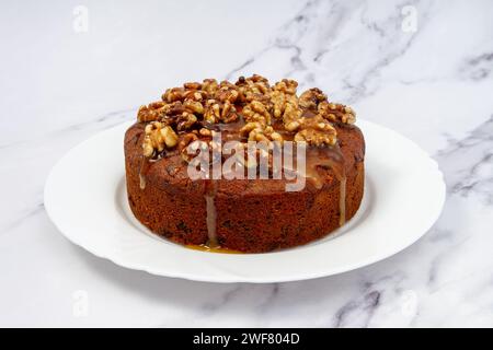 Gâteau aux dattes à la banane avec glaçage aux noix et au miel, sur assiette Banque D'Images