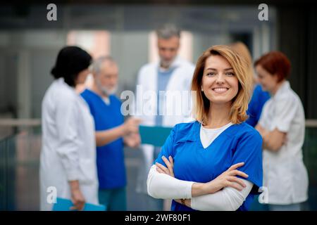 Portrait de belle femme médecin debout devant l'équipe de médecins. Collègues, équipe de médecins discutant du diagnostic des patients. Banque D'Images