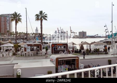 Malaga, Espagne- 26-01-2024 : scène vibrante à Puerto de Malaga avec des cafés en plein air, des palmiers et des yachts, une représentation parfaite de la vie côtière espagnole Banque D'Images