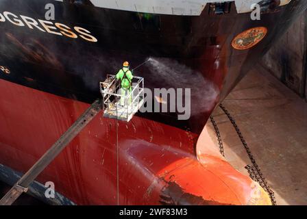 Image à angle élevé d'un docker nettoyant à la vapeur la coque d'un pétrolier en cale sèche. Banque D'Images