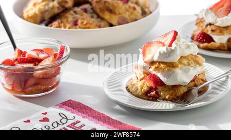 Portions de shortcakes à la fraise fraîchement préparés, contre une fenêtre ensoleillée. Banque D'Images