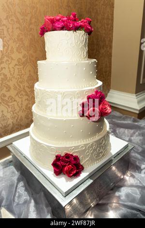 Un beau gâteau de mariage orné de roses délicates Banque D'Images