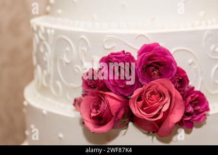 Un gâteau de mariage à trois niveaux orné de roses délicates Banque D'Images