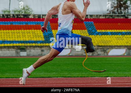 coureur masculin sprinter sur la piste de stade de course de prothèse, athlète handicapé para compétition d'athlétisme Banque D'Images