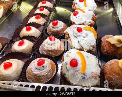 Italien, dessert sucré sicilien Cannoli, pâtisserie. Sicile, Italie, une personne dans une pâtisserie sicilienne sert des cannoli traditionnels à la ricotta avec candie Banque D'Images