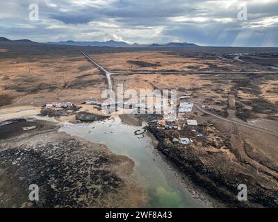 Vue aérienne d'un village côtier avec des routes sinueuses sur la côte nord aride de Fuerteventura, d'El Cotillo à Majanicho, près du feu de Faro del Toston Banque D'Images