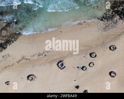 Vue aérienne de formations rocheuses spirales uniques sur les dunes de Corralejo avec des vagues débarquant à Fuerteventura Banque D'Images