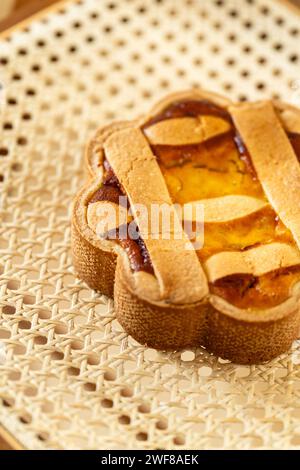 Une tarte napoletana pastiera de Pâques italienne, riche en saveurs d'agrumes, repose sur une chaise en rotin Banque D'Images