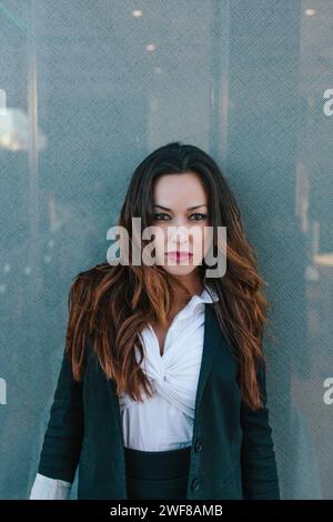 Une femme d'affaires professionnelle et prête à regarder les poses de la caméra avec un regard direct dans un environnement urbain, mettant en valeur le style et la confiance à Madrid, Banque D'Images