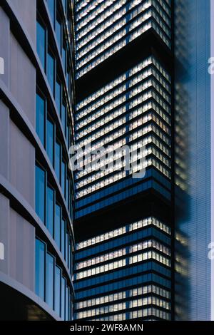 Gros plan de la façade contemporaine d'un immeuble de bureaux à Madrid, montrant le contraste du verre et de l'acier avec le ciel bleu. Banque D'Images