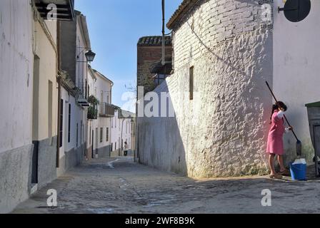 Jeune fille lavant la rue de Cuesta Santa Lucia dans la vieille ville de Ubeda, Andalousie, Espagne Banque D'Images