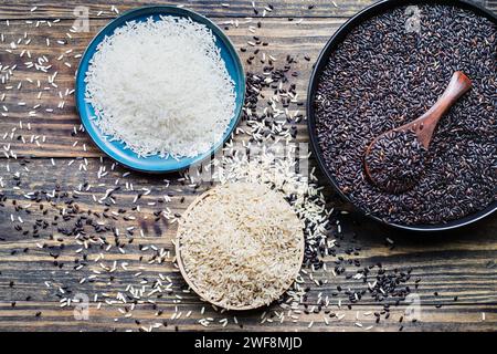 Bols pleins de grains différents. Riz Nerone, bio interdit noir, riz brun et riz au jasmin blanc. Vue à plat du dossier de la table. Banque D'Images
