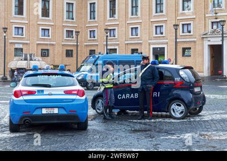 Piazza Papa Pio XII, Cité du Vatican - Mars 20 2018 : un policier et un carabinier discutent à côté de leur voiture respective. Banque D'Images