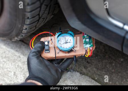 terroriste plaçant une bombe à retardement sous un véhicule Banque D'Images