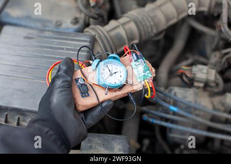 terroriste plaçant une bombe à retardement dans un moteur de véhicule Banque D'Images