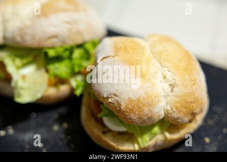 Sandwich au poisson avec laitue et œuf sur pain. mise au point sélective, gros plan. Banque D'Images