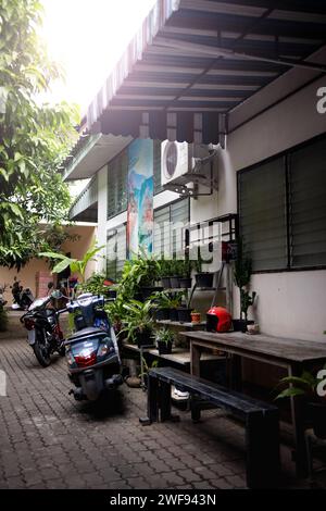 Une moto rouge vibrante est garée devant un grand bâtiment urbain dans une rue animée. Banque D'Images