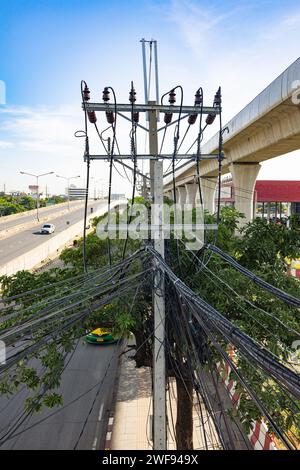 Une perspective aérienne capturant la présence de lignes électriques et de fils lorsqu'ils se croisent et traversent un environnement urbain. Banque D'Images