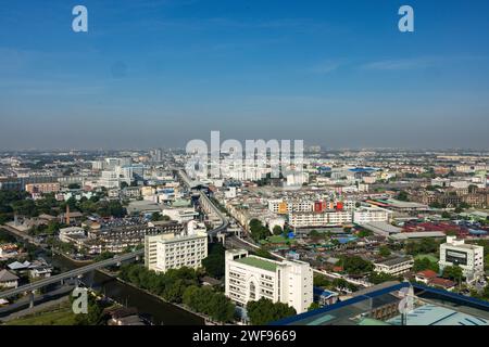 Cette photo capture le paysage urbain panoramique de Bangkok vu du haut d'un bâtiment, mettant en valeur la vie urbaine animée et les monuments architecturaux Banque D'Images