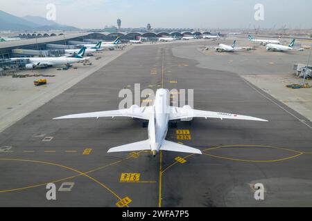 Aéroport international Chek Lap Kok avec terminal très fréquenté. Avion sur la voie de circulation de l'aéroport de Hong Kong, également connu sous le nom d'aéroport HKG. Banque D'Images