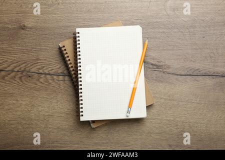 Cahiers et crayon sur table en bois, vue de dessus Banque D'Images