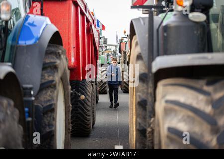 Argenteuil, France. 29 janvier 2024. Un jeune agriculteur est vu au milieu des tracteurs pendant la grève des agriculteurs. Suite à la grève des agriculteurs français, le début de la semaine a été marqué par le blocage de huit des principaux points d'accès à la capitale française. A Argenteuil, au nord de Paris, environ 30 tracteurs bloquent l'autoroute A15. Crédit : SOPA Images Limited/Alamy Live News Banque D'Images