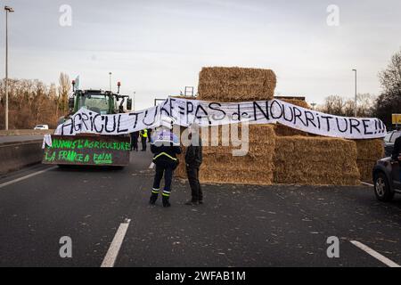 Argenteuil, France. 29 janvier 2024. Un policier parle à un agriculteur pendant la grève des agriculteurs. Suite à la grève des agriculteurs français, le début de la semaine a été marqué par le blocage de huit des principaux points d'accès à la capitale française. A Argenteuil, au nord de Paris, environ 30 tracteurs bloquent l'autoroute A15. Crédit : SOPA Images Limited/Alamy Live News Banque D'Images